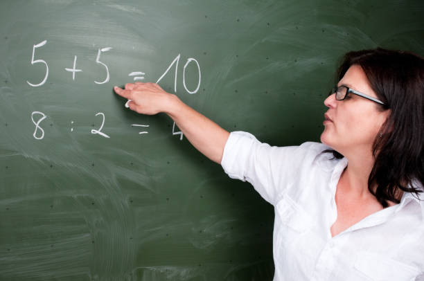 istock Female teacher standing at blackboard, teaching mathematics 157617826