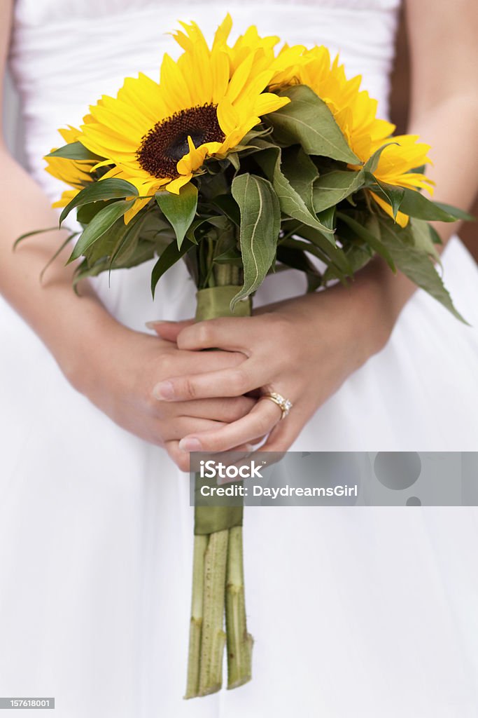 Sunflower Bridal Bouquet Close up view of a sunflower bouquet held by a bride. Adult Stock Photo