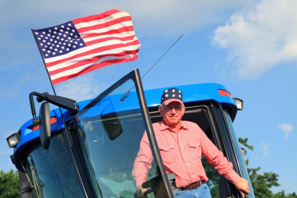 landwirtschaft: patriotische amerikanische farmer am traktor mit flagge - flag of oklahoma stock-fotos und bilder