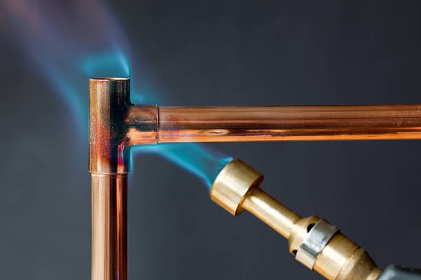 Gas flame heating copper piping before soldering Gas flame heating copper piping before soldering fire alphabet letter t stock pictures, royalty-free photos & images