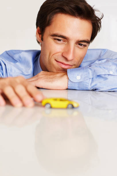 istock Thoughtful business man looking at toy car 157618354