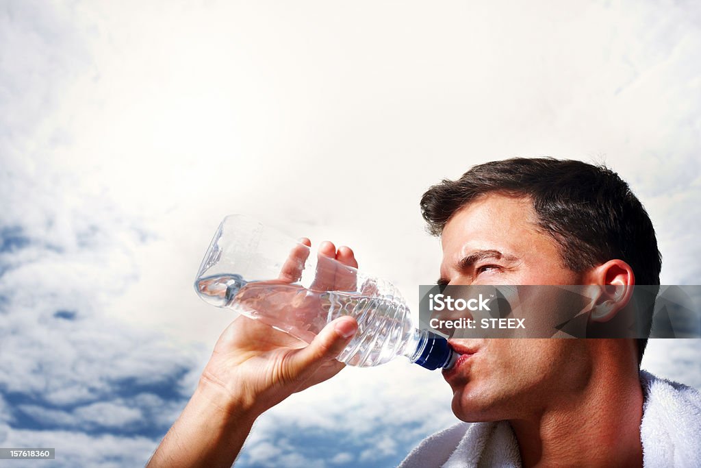 Zbliżenie o średnim wieku człowiek wody pitnej po treningu - Zbiór zdjęć royalty-free (30-34 lata)