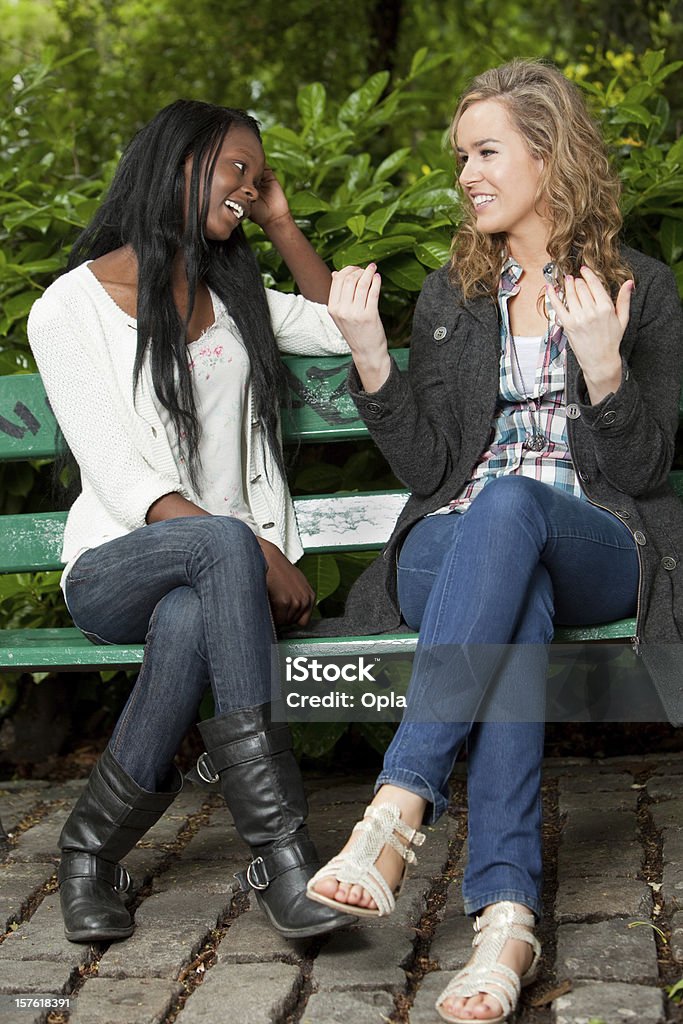 Dois amigos sentado em um Banco de Parque a conversar - Royalty-free Banco - Assento Foto de stock