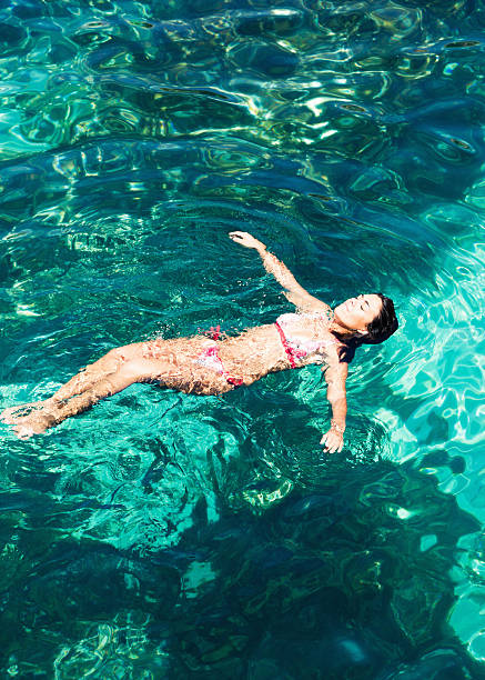 istock Beautiful Woman Floating on Sea Surface 157618812