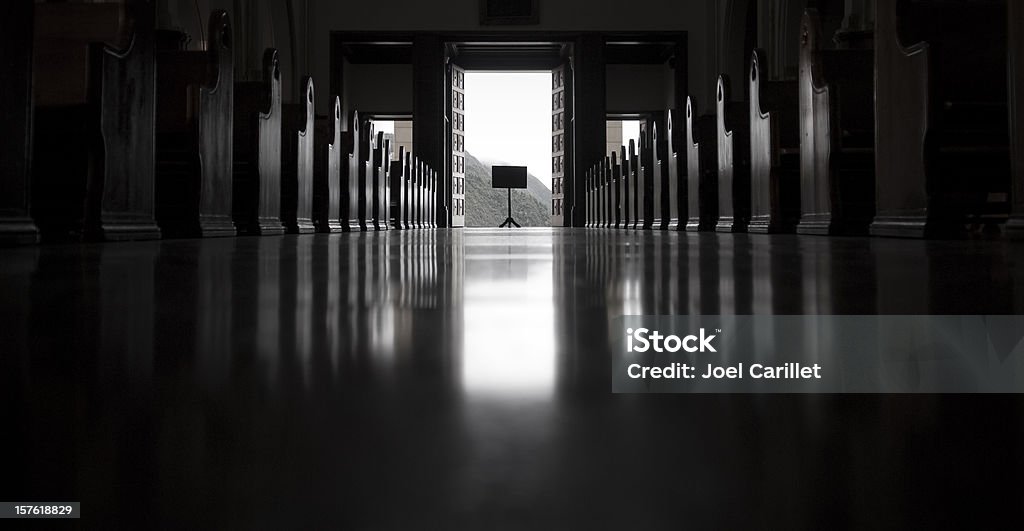 Empty Church, looking toward the open exit with sign An empty church, looking toward the open exit Pew Stock Photo