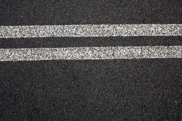 An elevated view shot of double white lines on a road.