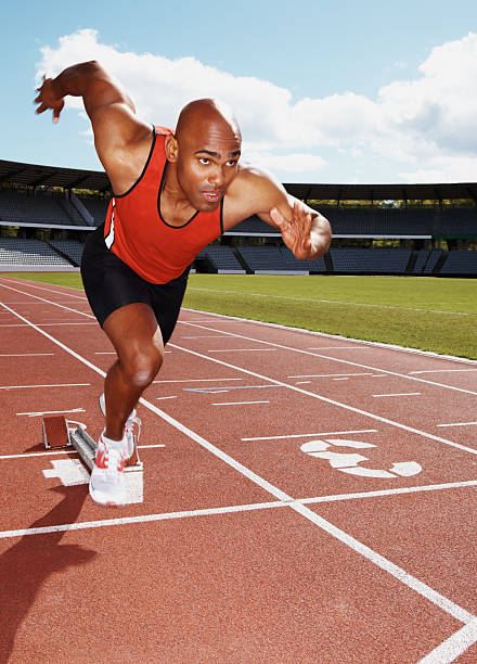 istock Male athlete launching off the start line in a race 157619040