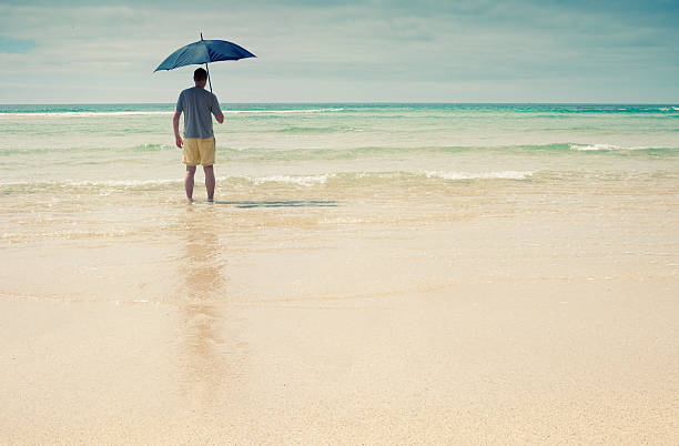 Man with Umbrella walking into the sea