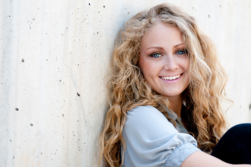 A beautiful young woman with a soft smile and striking blue eyes.