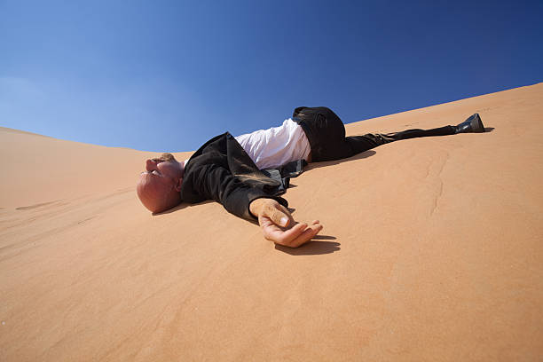 istock fallen businessman in desert very low perspecitve 157619555