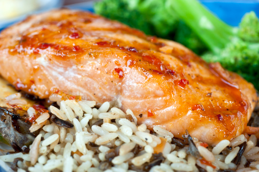 Wood-grilled fresh salmon, brushed with sweet and spicy glaze and served over wild rice pilaf with grilled pineapple.
