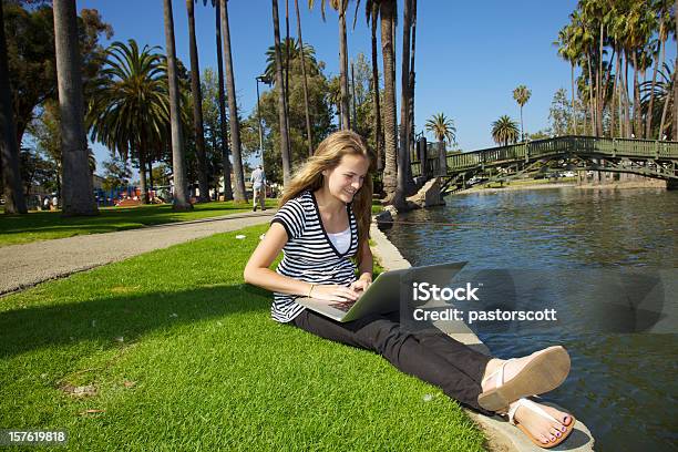 Pretty Teenage Girl Reading On Laptop In Park Los Angeles Stock Photo - Download Image Now