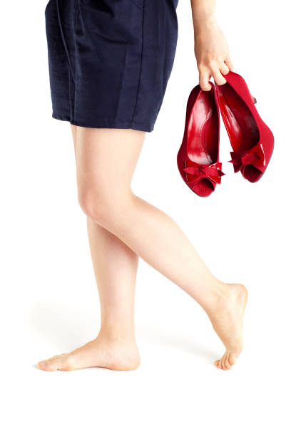 >Elegant woman in high heels walking in corridor with luggage