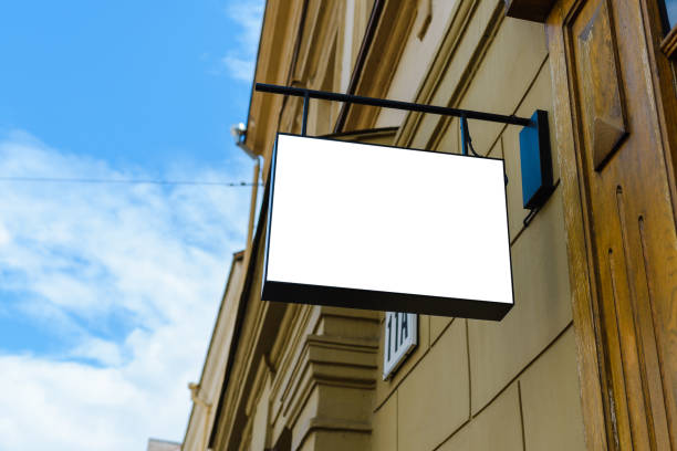 istock Blank white signboard mockup. Empty illuminated shop lightbox template mounted on wall. Mock up of illuminated blank signboard. Place for text, outdoor advertising, banner. 1576211672
