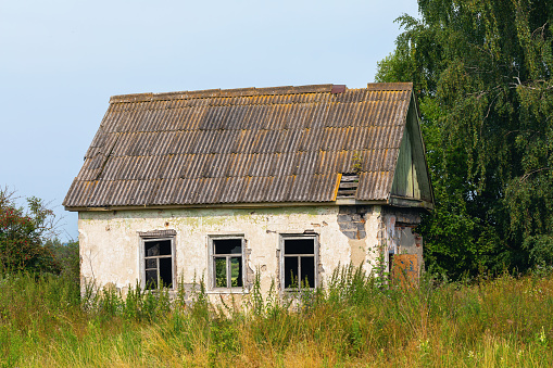 Old abandoned village house and land plot in the field