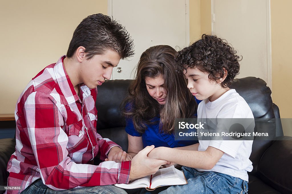 Christian Family Praying Christian family pray in their daily devotional at home Family Stock Photo