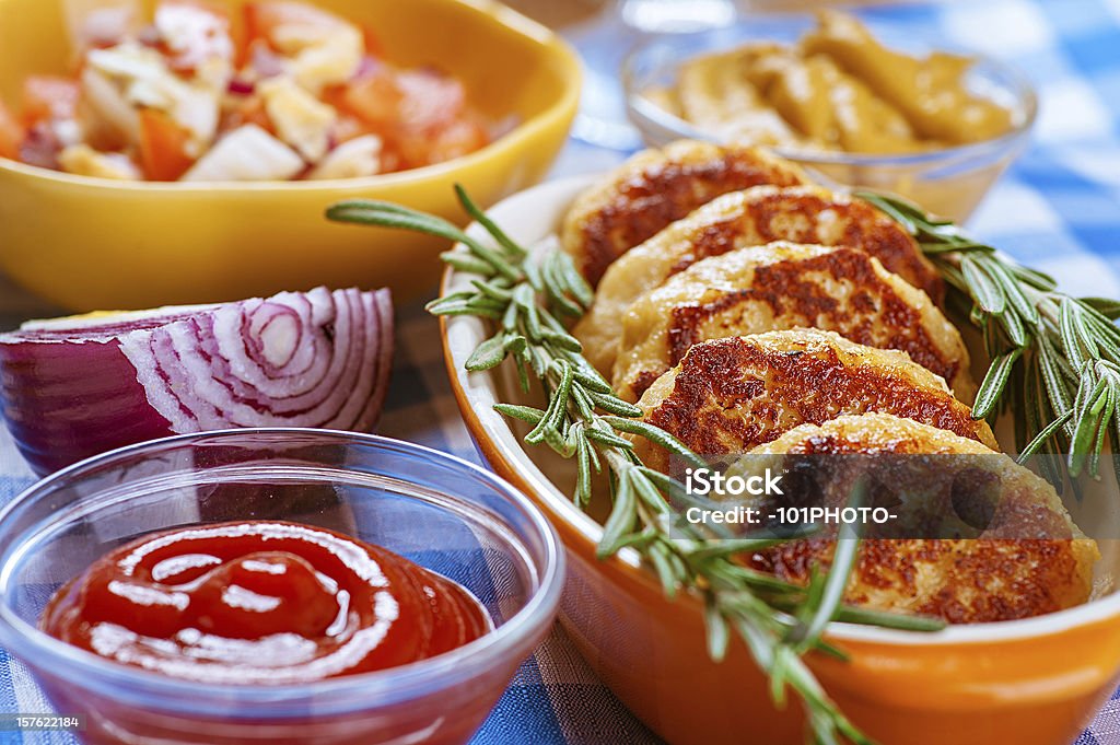 chops, ketchup, onion, mustard and salad Pork chops, ketchup, onion, mustard and salad on blue napkin. Beef Stock Photo