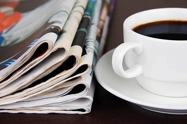 Take a break Pile of newspapers and cup of coffee on the table. weekend activities stock pictures, royalty-free photos & images