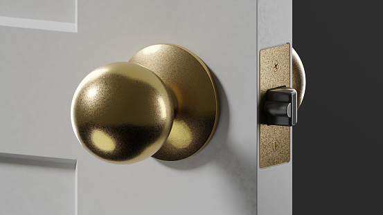 Closeup of gold door knob on partially open door