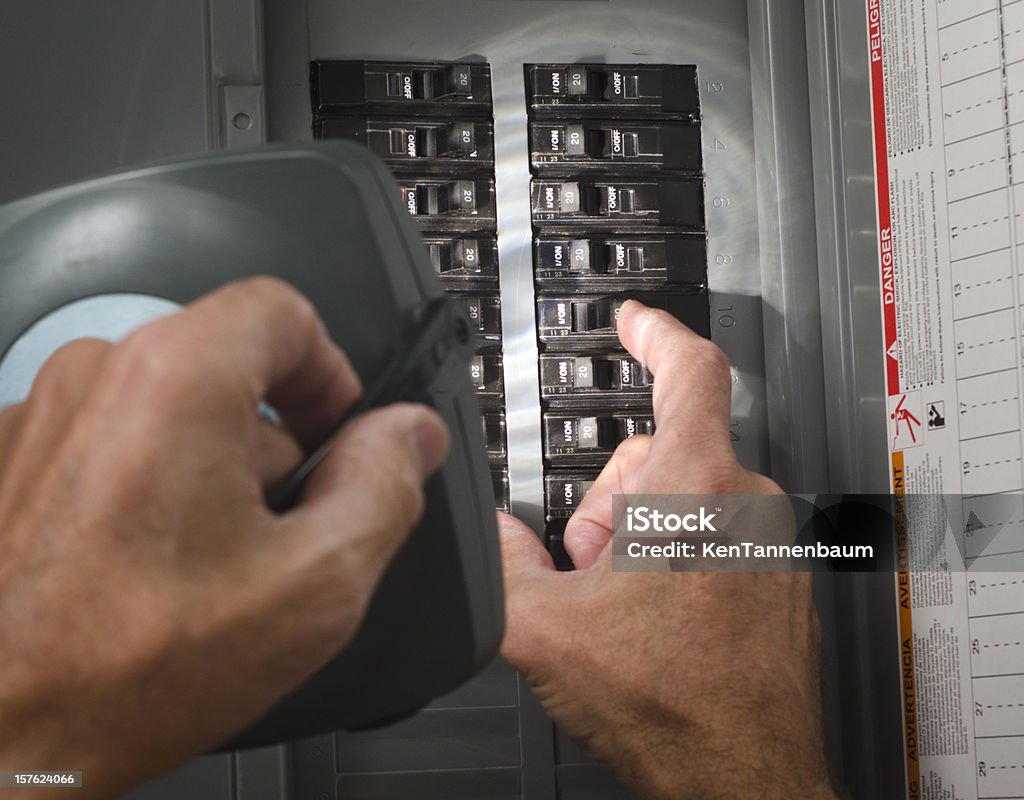 Homme avec lampe de poche au circuit breaker écran plat résidentiel - Photo de Armoire à fusibles libre de droits