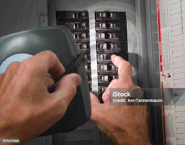 Photo libre de droit de Homme Avec Lampe De Poche Au Circuit Breaker Écran Plat Résidentiel banque d'images et plus d'images libres de droit de Armoire à fusibles