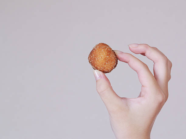 istock young woman holding a delicious sugar donut 157627678