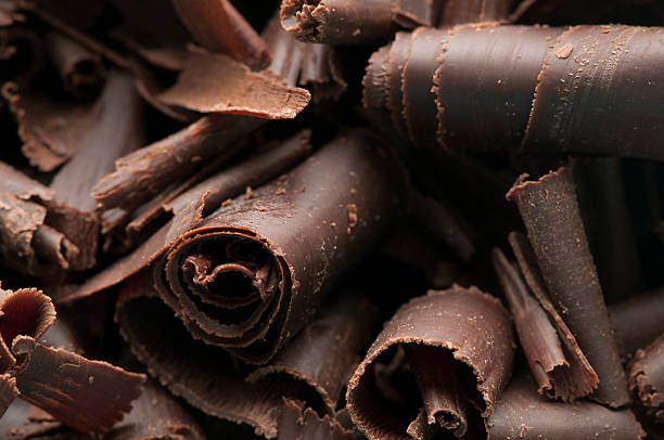 Chocolate Shavings Background Close-up of homemade dark chocolate shavings curled up photos stock pictures, royalty-free photos & images