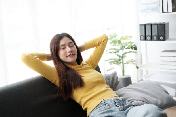istock Relaxed happy young woman relax on comfortable couch at home sleeping or taking nap. 1576277617