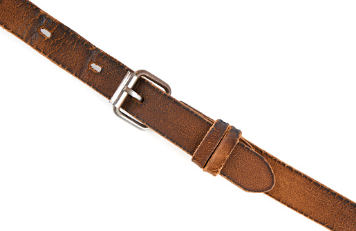 Old leather men's belt on a white background. Brown belt for men. Brown leather belt for trousers and jeans. Male accessory. Vintage things.