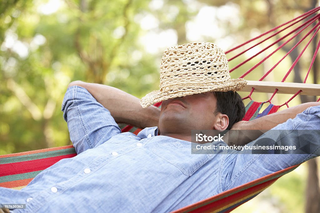 Man lying in hammock Man In Garden Relaxing In Hammock Hammock Stock Photo