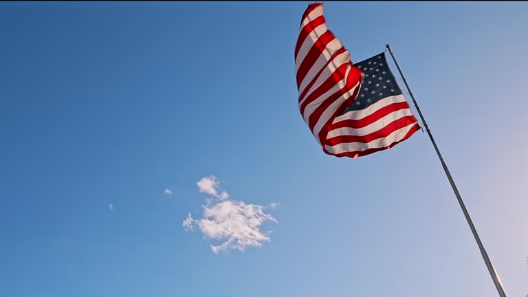 American USA flag on a flagpole waving in the wind