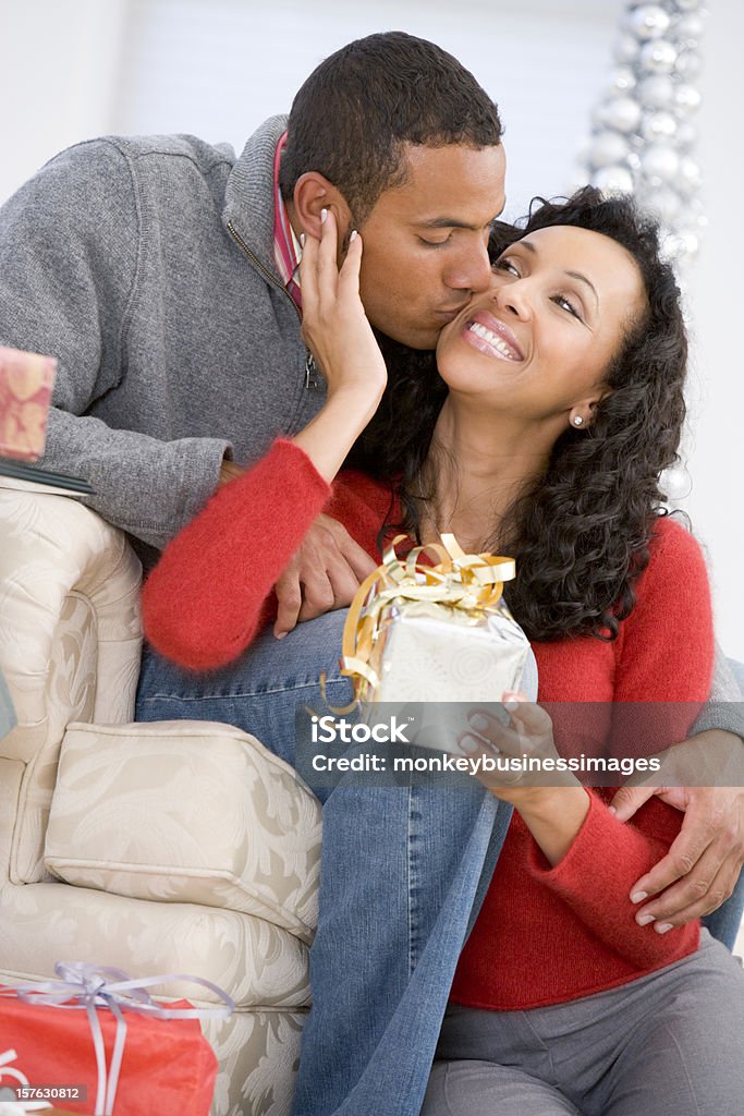 Esposo y esposa afectuosamente intercambiando regalos de Navidad - Foto de stock de Regalo libre de derechos