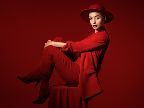 young woman in black hat with red lips on black