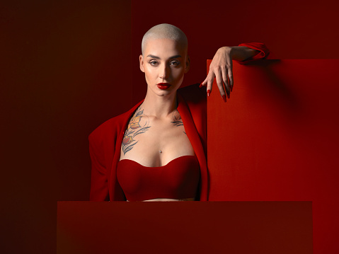 Fashion, portrait and confident woman in red suit in studio isolated on a background mockup space. Face, makeup and serious female model with cosmetics, aesthetic or classy clothes from Switzerland.