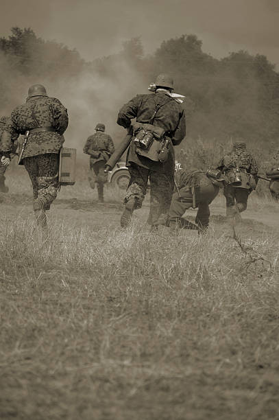 Military running in sepia tones WW2  German soldiers attack an enemy position.Picture has been aged to give the feel of a vintage shot. battle photos stock pictures, royalty-free photos & images