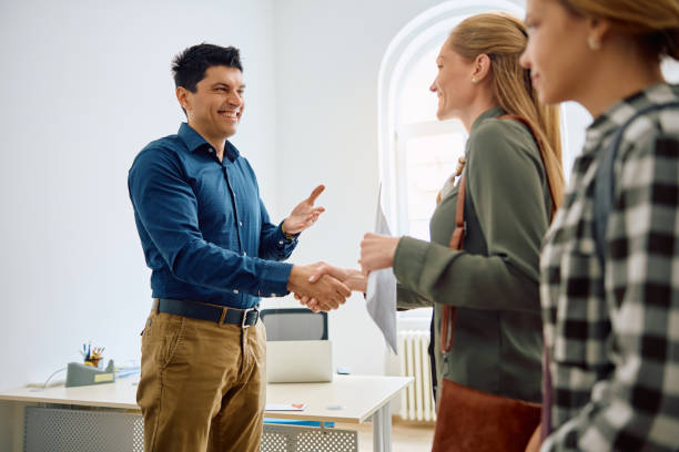 wir freuen uns, dass ihre tochter an unserer schule angemeldet ist! - greeting teenager handshake men stock-fotos und bilder