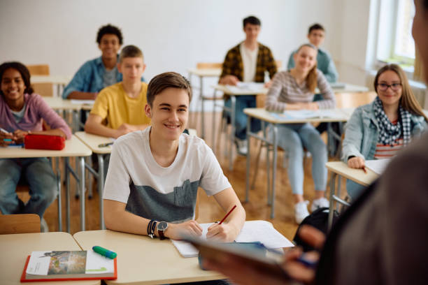 istock Group of students listening teacher's lecture during a class at high school. 1576355811