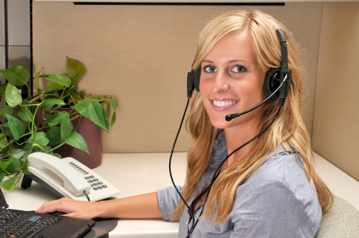 Customer service operator using computer during telephone conversation.