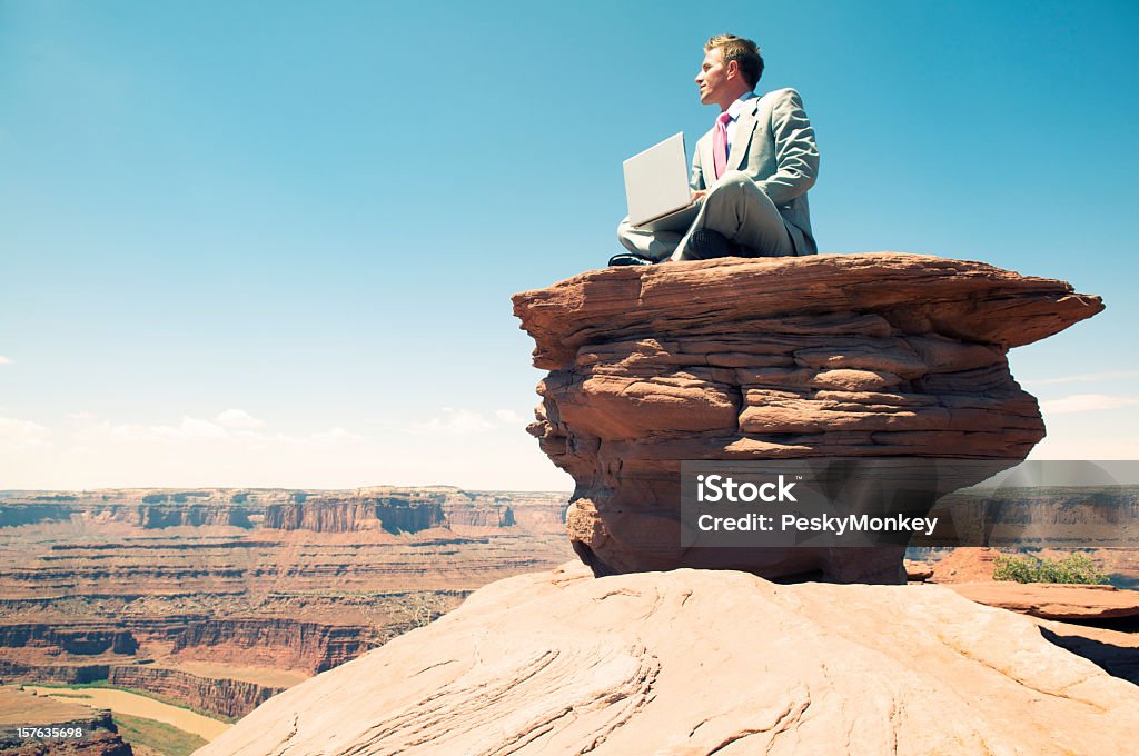 Viaje Ejecutivo sentado con el portátil en Rock Mesa - Foto de stock de Grand Canyon libre de derechos