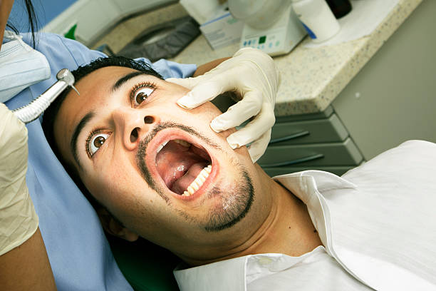Dentist nightmare Man staring at the dentist drill with a frightened expression. dental drill stock pictures, royalty-free photos & images