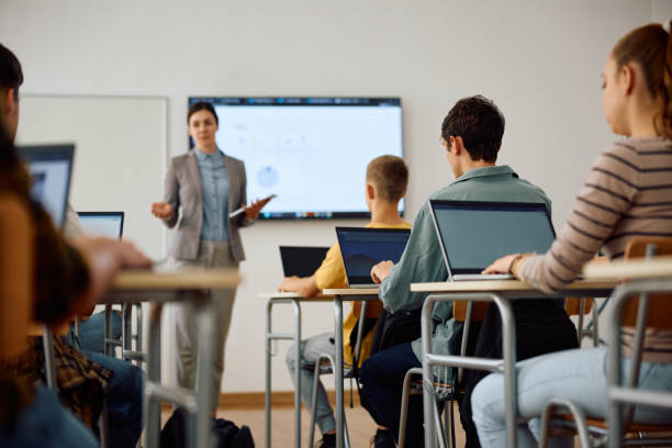 Group of high school students attending computer class in the classroom. High school student and his classmates learning computer coding on a laptops in the classroom. digital native stock pictures, royalty-free photos & images