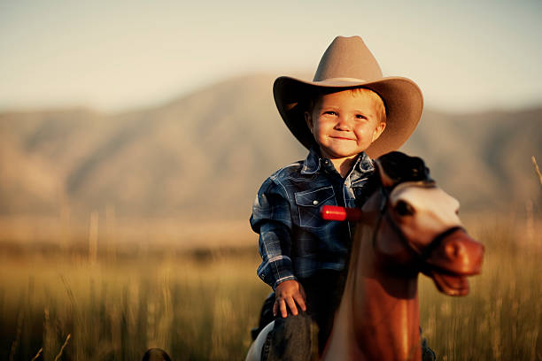 Happy Cowboy A young cowboy is happy to be on his horse. texas cowboy stock pictures, royalty-free photos & images