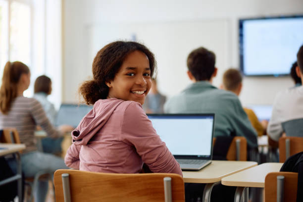 istock Happy black female student during computer class at high school looking at camera. 1576358101