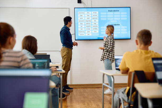 istock High school student and her teacher using smartboard during a lecture in the classroom. 1576358673