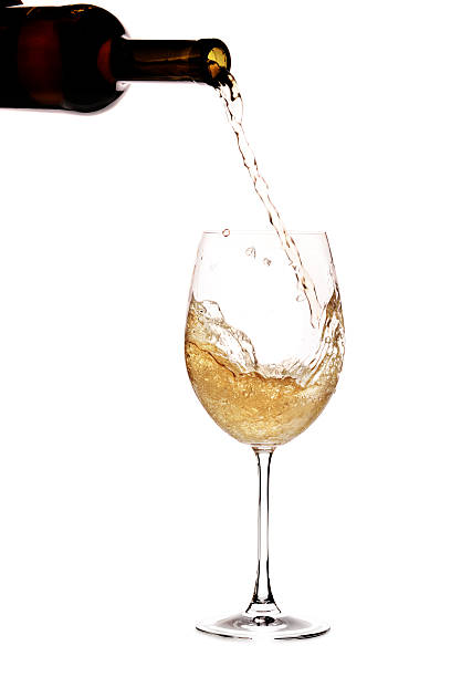 White wine being poured into a glass stock photo