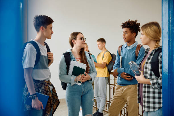 istock Multiracial group of students talking in a hallway at high school. 1576359851