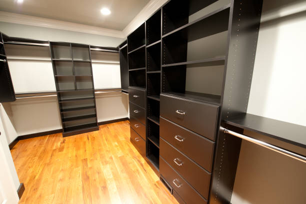 istock Walk-in closet with black wood paneled cabinets 157636197