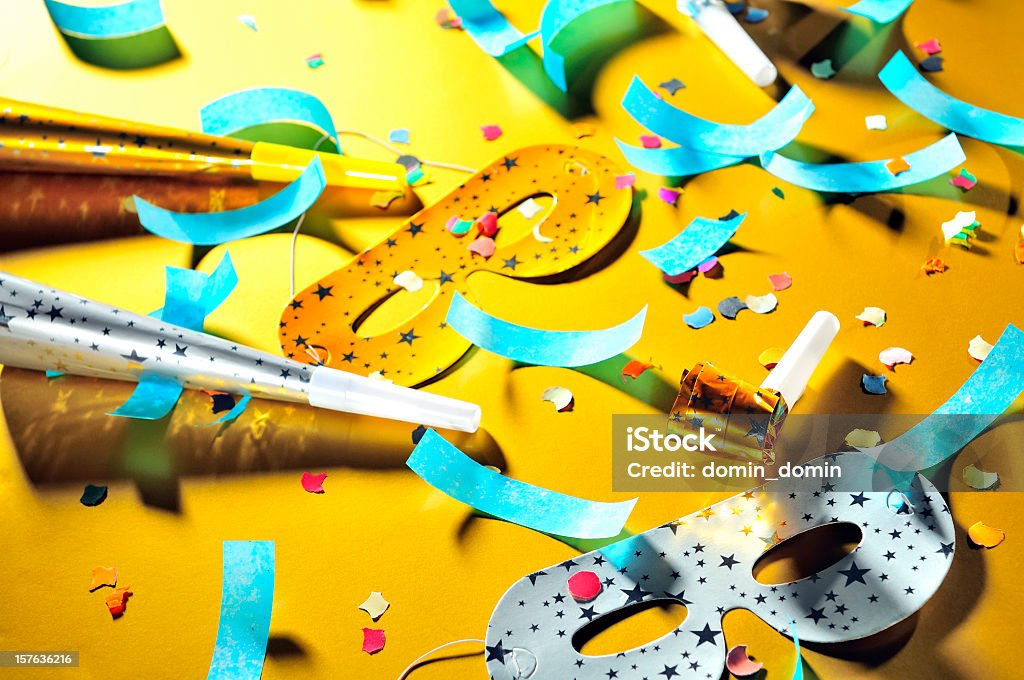 Mess after party, decorations: masks, whistles, horns, confetti scattered floor Let's celebrate! Mess after party, decorations: masks, whistles, horns, confetti are scattered on the floor, golden background. Party - Social Event Stock Photo