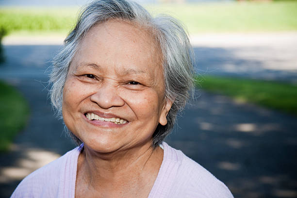 Asian senior woman smiling with white shirt stock photo