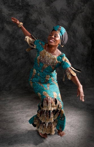 Black female African dancer in authentic African clothing and headdress telling a story with her body and hands. Studio lighting and background in vertical format.http://www.garyalvis.com/images/conceptsIdeas.jpg